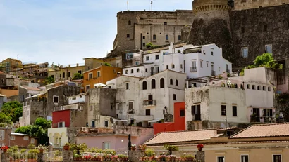 Veduta di case colorate e fortezza su una collina sotto il cielo azzurro