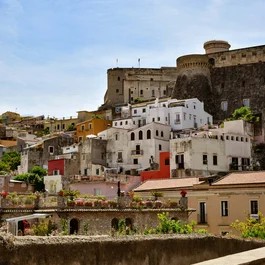 Veduta di case colorate e fortezza su una collina sotto il cielo azzurro