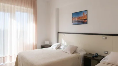 Camera da letto luminosa con due letti e tende color crema