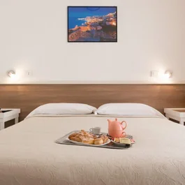 Camera da letto con letto matrimoniale e vassoio con colazione