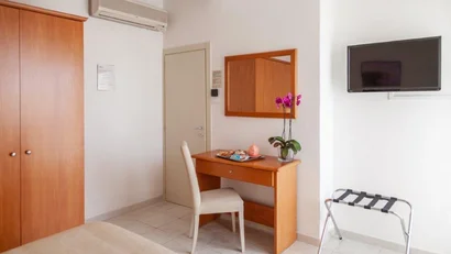 Camera con scrivania, sedia, televisore e armadio in legno